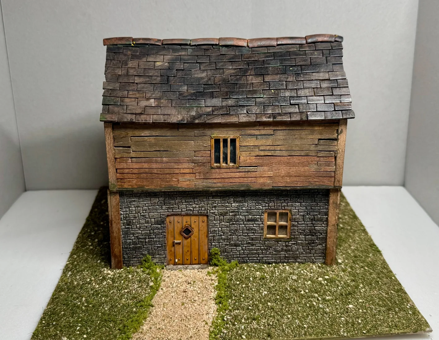 Two-storey miniature house with stone ground floor and timber upper floor